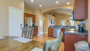 A modern kitchen with wooden cabinets, a stainless steel refrigerator, and a dishwasher. - Bright Peoria Home w/ Gas Grill & Fire Pit! (Peoria)