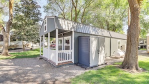 A small, single-story cabin with a porch and a garage.
