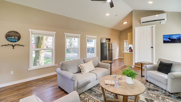A spacious living room with a gray sofa, a round coffee table, and a ceiling fan.