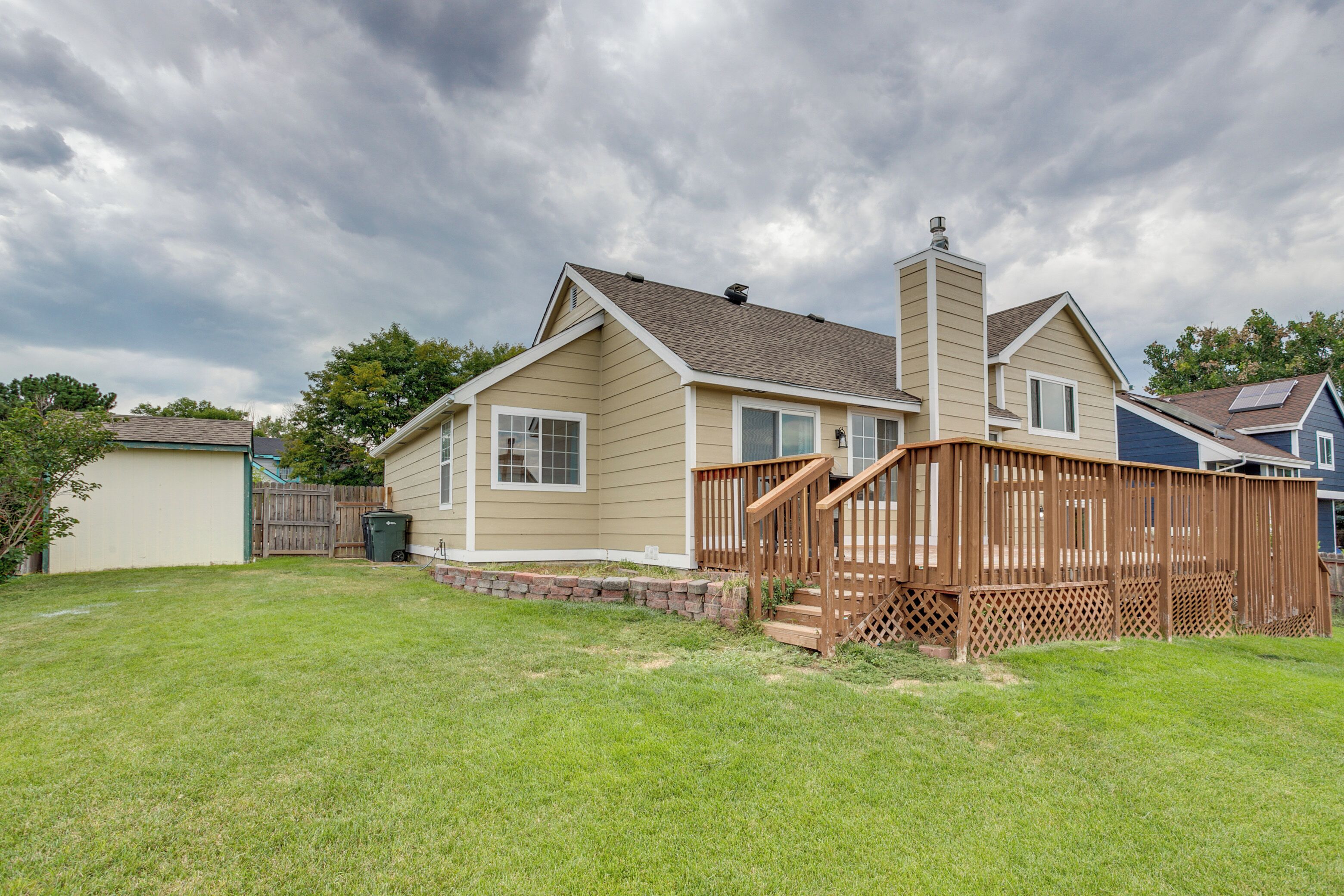 A single-story house with a front deck and a chimney.