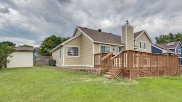 A single-story house with a front deck and a chimney.