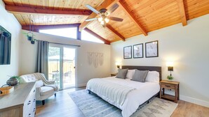 A bedroom with a bed, bedside table, and a desk with a chair. There is a ceiling fan, a window, and a door leading to a balcony. - Pet-friendly Monterey Home 2 Mi to Beach (Monterey)