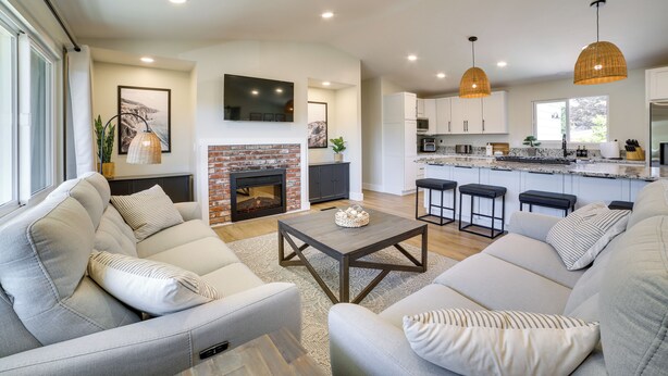 A modern living room with a fireplace, sofas, and a kitchen area with bar stools. - Pet-friendly Monterey Home 2 Mi to Beach (Monterey)