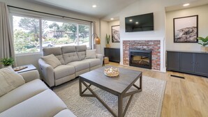 A modern living room with a sofa, coffee table, fireplace, and large windows. - Pet-friendly Monterey Home 2 Mi to Beach (Monterey)