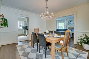 Dine in style with a beautifully set table for four, complete with a chandelier and comfortable seating.