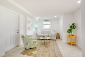 Relax in a spacious living area with a sofa, armchair, and coffee table, perfect for unwinding.