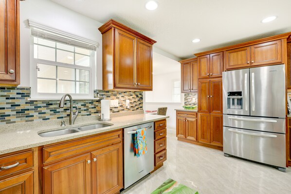 Features a double sink, oven, and stainless steel appliances.