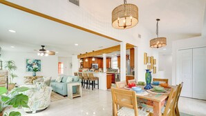 A spacious living area with a dining table, chairs, and a kitchen in the background. - St Augustine Home Near Vilano Beach: Pets Welcome! (St. Augustine)