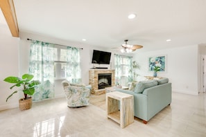 Relax in this stylish living room with a sofa, armchair, and flat-screen TV.