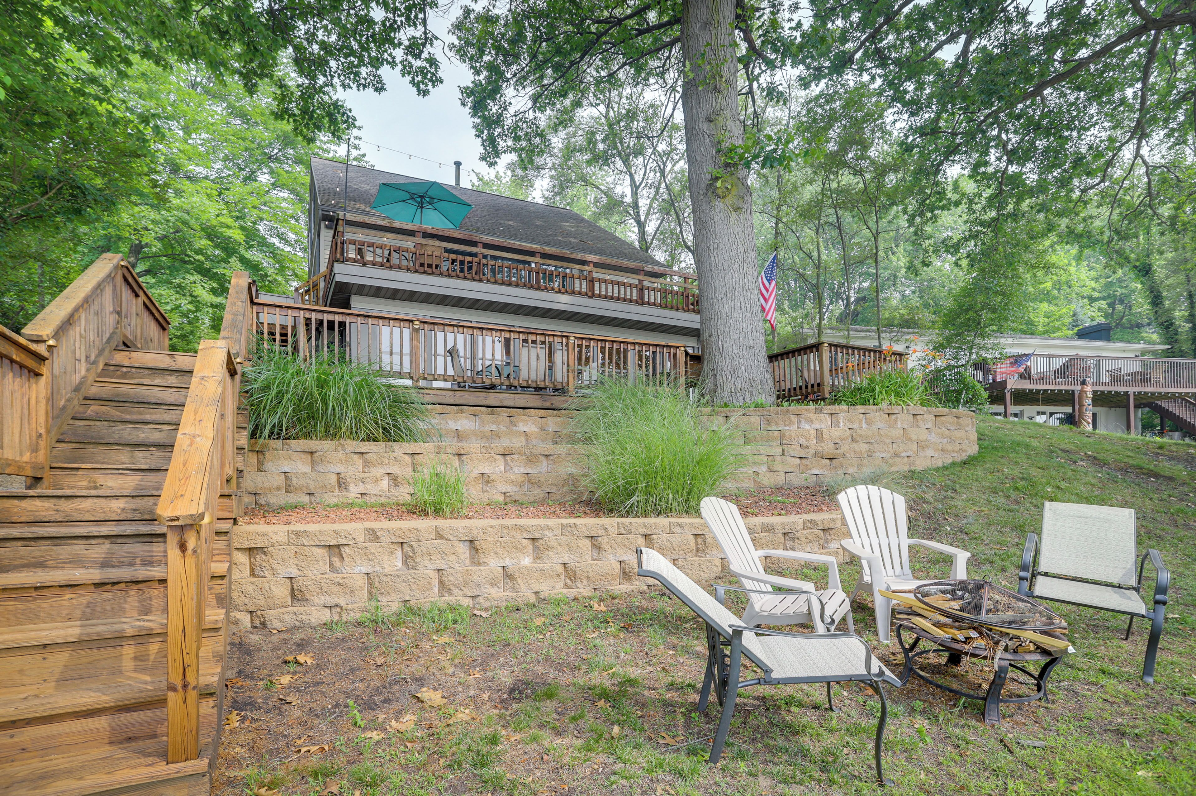 A wooden deck with outdoor seating and a stone retaining wall.