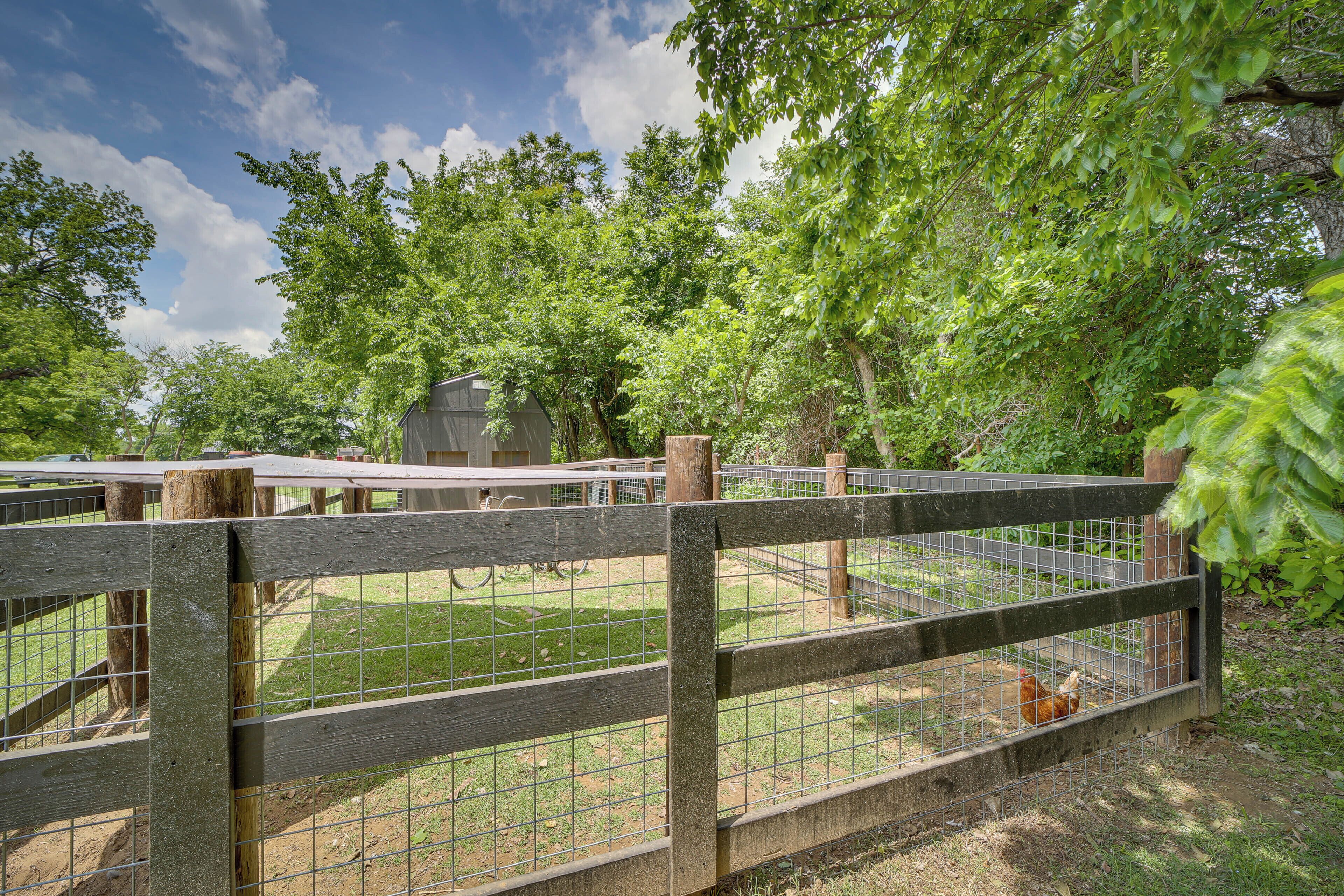 A fenced outdoor area with a wooden structure and a wire fence.