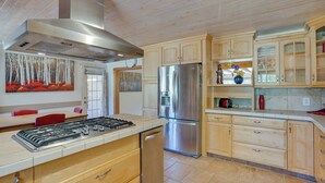 A modern kitchen with wooden cabinets, stainless steel appliances, and a central island. - Beautiful Ouray Home w/ Patio - 3 Mi to Downtown! (Ouray)