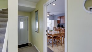 A hallway leading to a dining area with a table and chairs, a ceiling fan, and a door with a window. - Comfortable Milwaukee Abode ~ 10 Mi to Downtown! (Milwaukee)