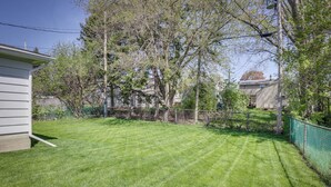 A well-maintained lawn with a wooden fence and trees. - Comfortable Milwaukee Abode ~ 10 Mi to Downtown! (Milwaukee)