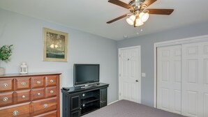 A bedroom with a bed, dresser, TV, ceiling fan, and two doors. - Comfortable Milwaukee Abode ~ 10 Mi to Downtown! (Milwaukee)