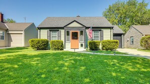 Une maison à deux étages avec un porche à l’avant, un garage et une pelouse bien entretenue.