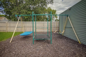 A playground with a swing set and a trampoline.