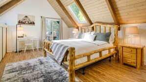 A cozy bedroom with a wooden bed, a desk, and a window with a view. - Steps to Lake Arrowhead: Cabin w/ Full Lake Access (Lake Arrowhead)