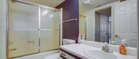 A bathroom with a toilet, a sink, and a shower.