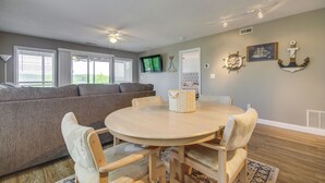 Un salon chaleureux avec une table ronde en bois, un canapé gris et une décoration sur le thème de la marine.
