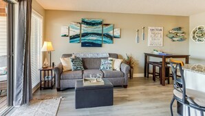 A living room with a grey sofa, a coffee table, a lamp, and a wall art piece. - Pool Access & Lake View: Osage Beach Condo! (Osage Beach)