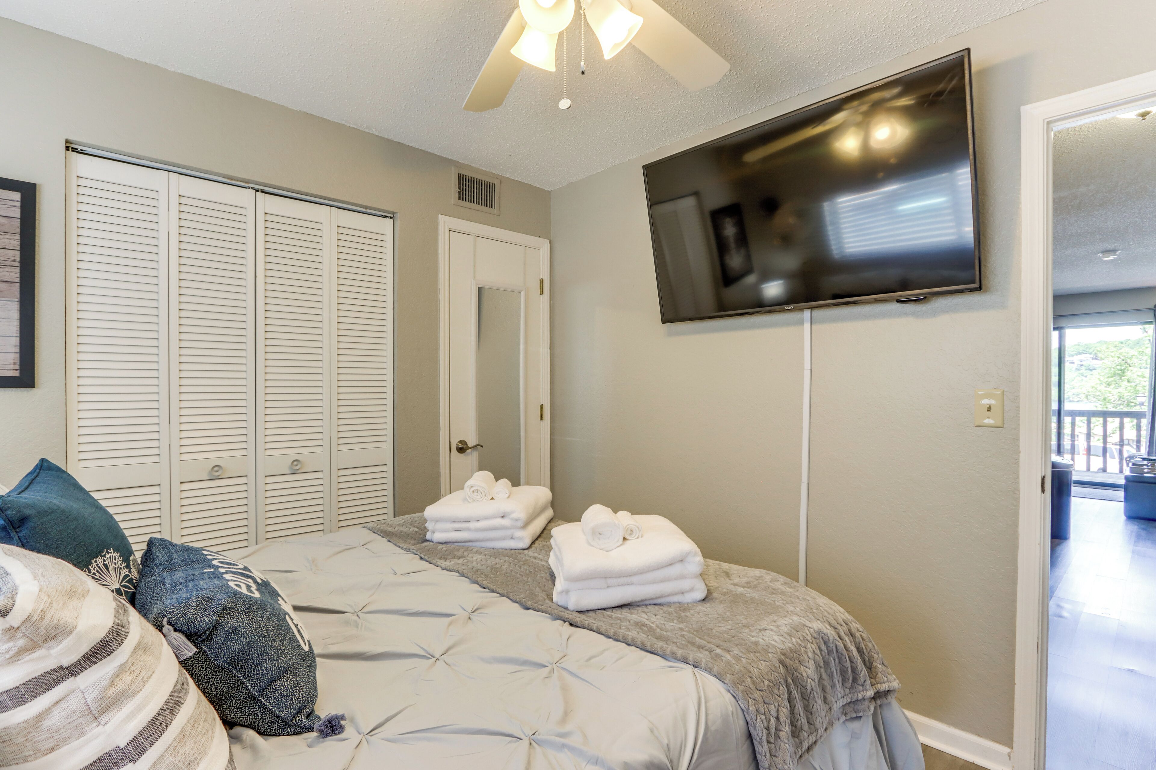 A bedroom with a bed, a TV, and a closet.