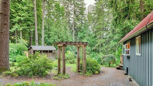 A rustic wooden pergola in a forested area with a cobblestone path leading to a cabin. - Peaceful Mt. Hood Cabin w/ Hot Tub & Fire Pit! (Rhododendron)