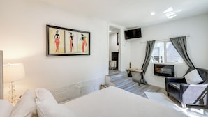 Une chambre d’hôtel avec un lit, une télévision, un bureau et une chaise.
