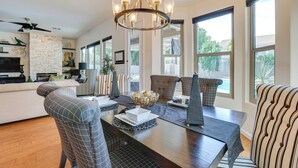 A modern dining area with a dark wooden table, patterned chairs, and a chandelier. - Retreat w/ Outdoor Oasis! Day Trip to Dtwn Phoenix (Peoria)