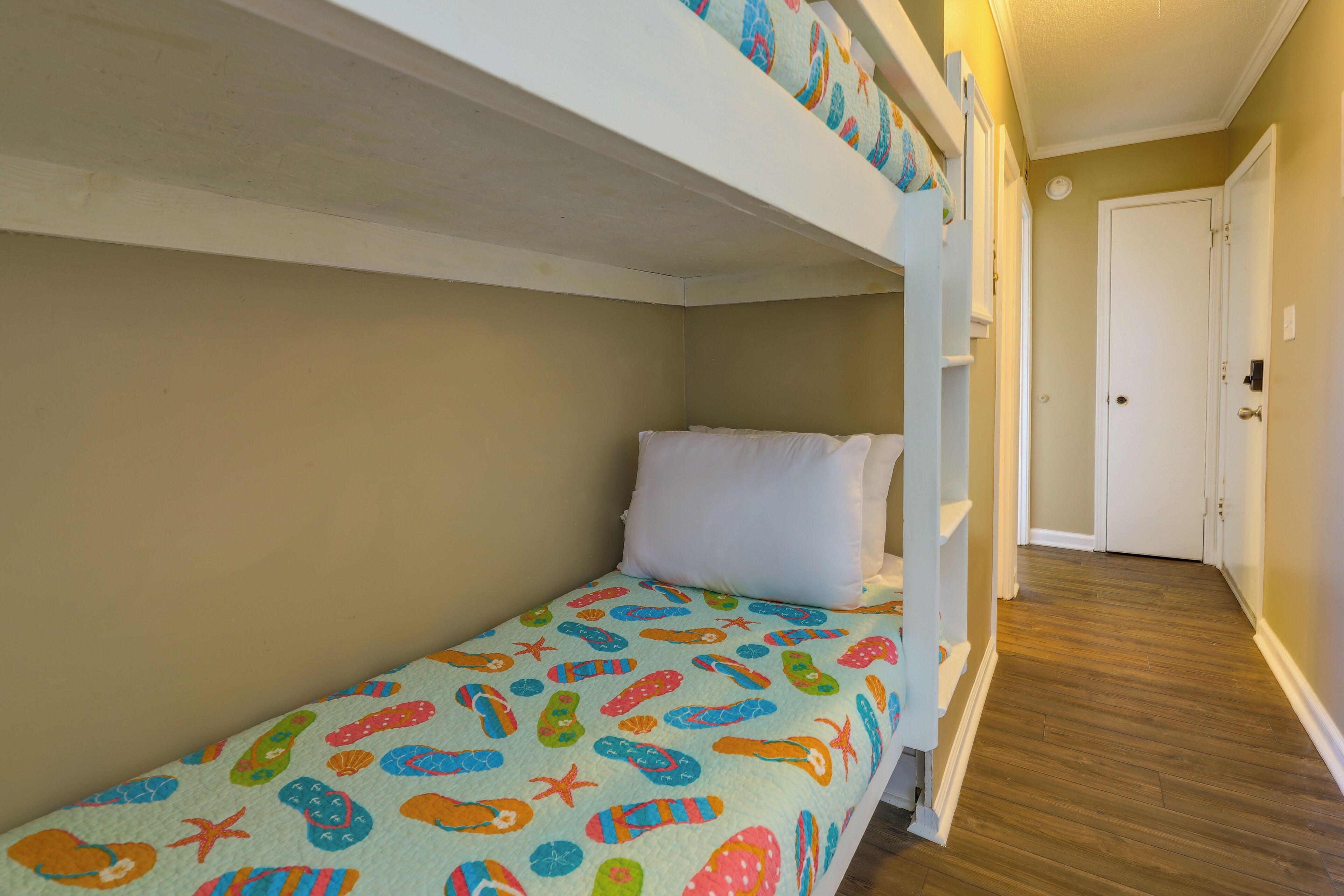 A bunk bed with a colorful bedspread and a white pillow.