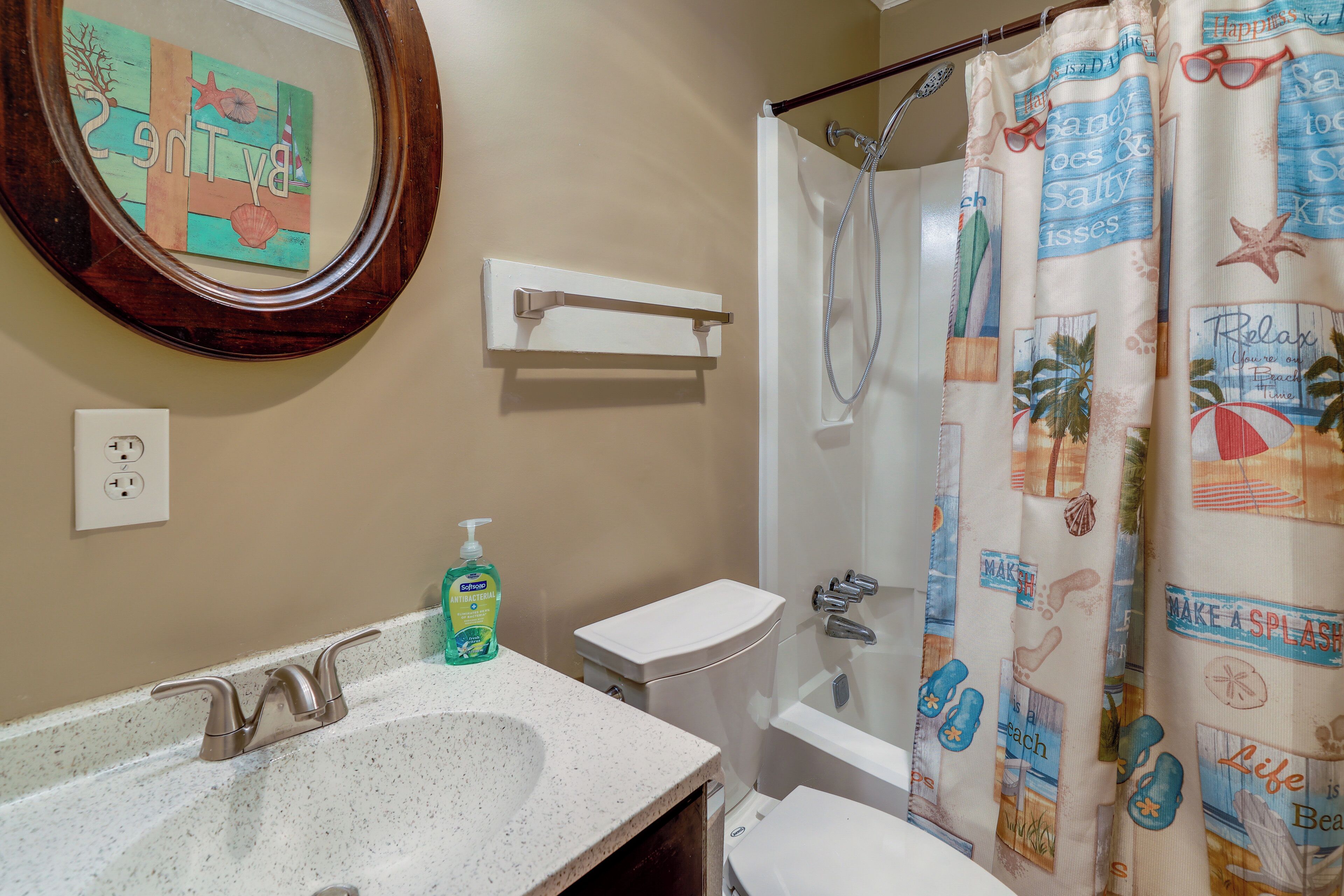 A bathroom with a sink, toilet, and shower curtain.
