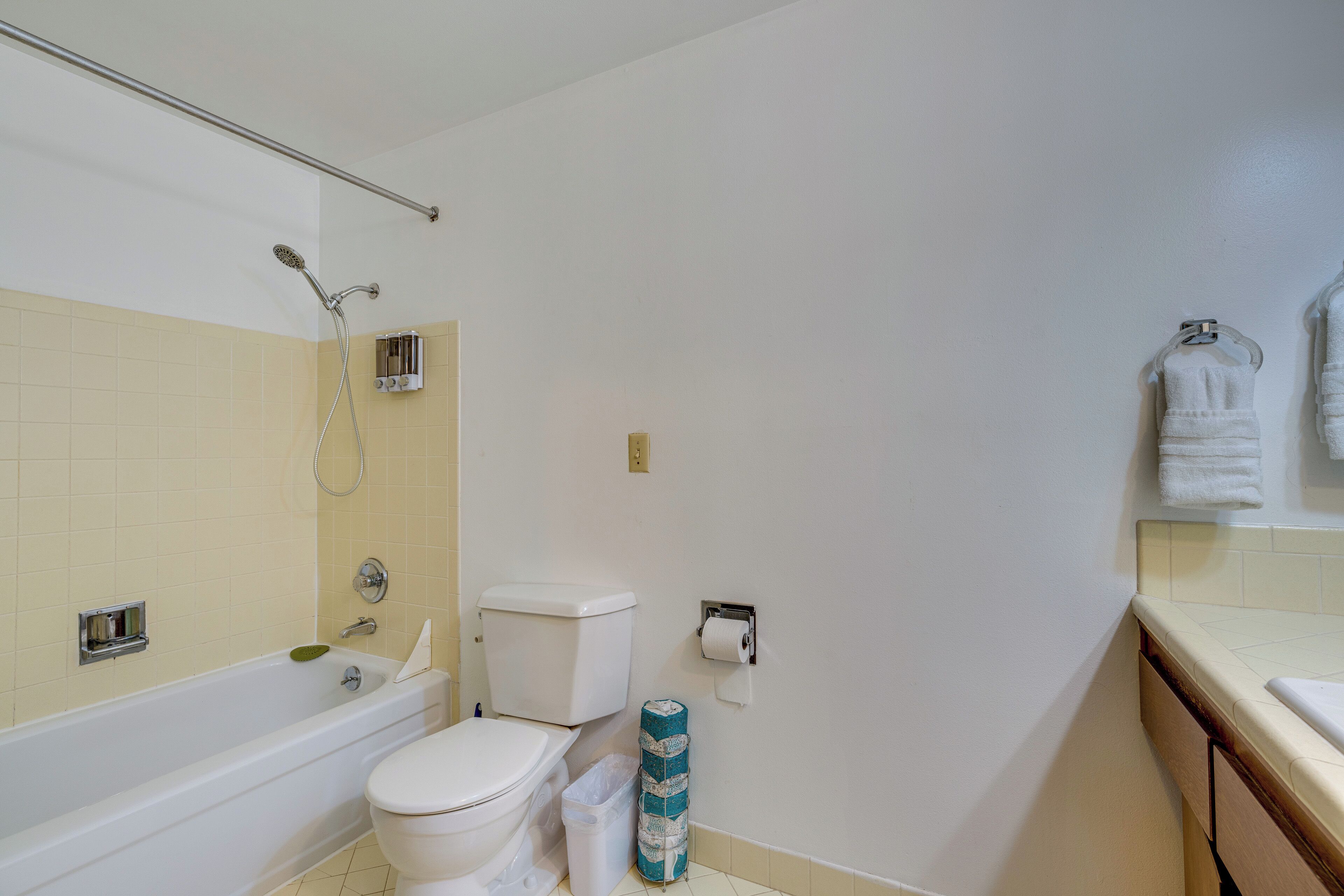 A bathroom with a bathtub, toilet, and towel rack.
