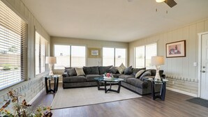 A living room with a sectional sofa, two side tables, a coffee table, and a ceiling fan.