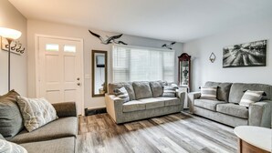 A living room with two grey sofas, a coffee table, and a wooden floor. - 4 Mi to Dtwn Rochester: Charming Apt w/ Patio! (Rochester)