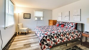 A bedroom with a bed, a chair, a desk, and a wall with three framed pictures. - 4 Mi to Dtwn Rochester: Charming Apt w/ Patio! (Rochester)