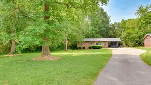A residential property with a paved driveway leading to a brick house with a garage. - Pet-friendly Greenville Vacation Rental w/ Deck! (Greenville)