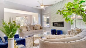 A modern living room with a sofa, coffee table, and decorative plants. - Upscale Pflugerville Paradise w/ Private Pool! (Pflugerville)