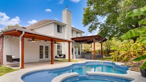 A backyard with a swimming pool, a covered patio, and a house with a chimney. - Upscale Pflugerville Paradise w/ Private Pool! (Pflugerville)