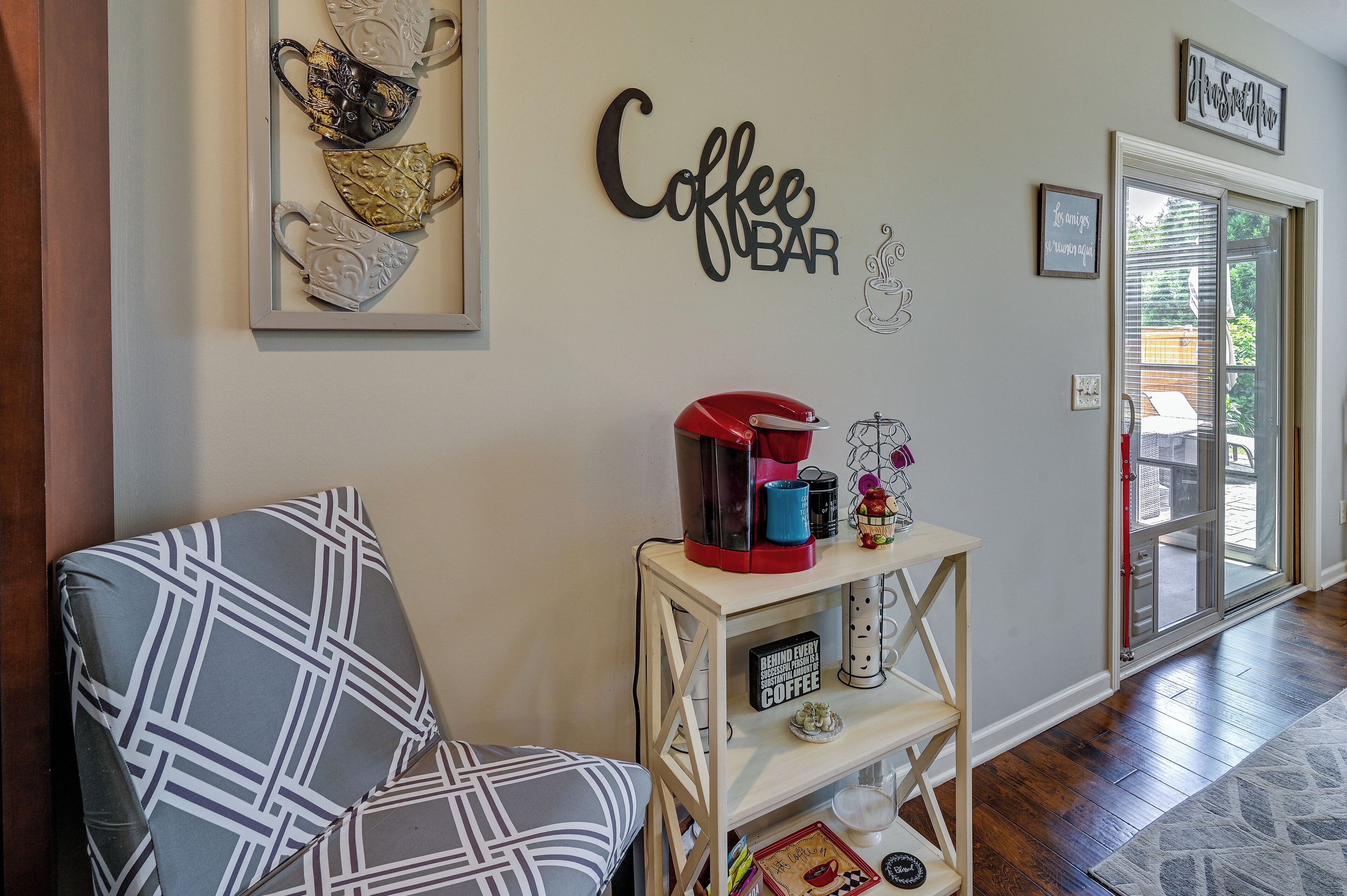 Una sala de estar con una barra para café, un sofá estampado y decoración en la pared.