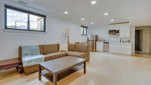 Una sala de estar moderna con un sofá, una mesa de centro y vistas al área de la cocina.