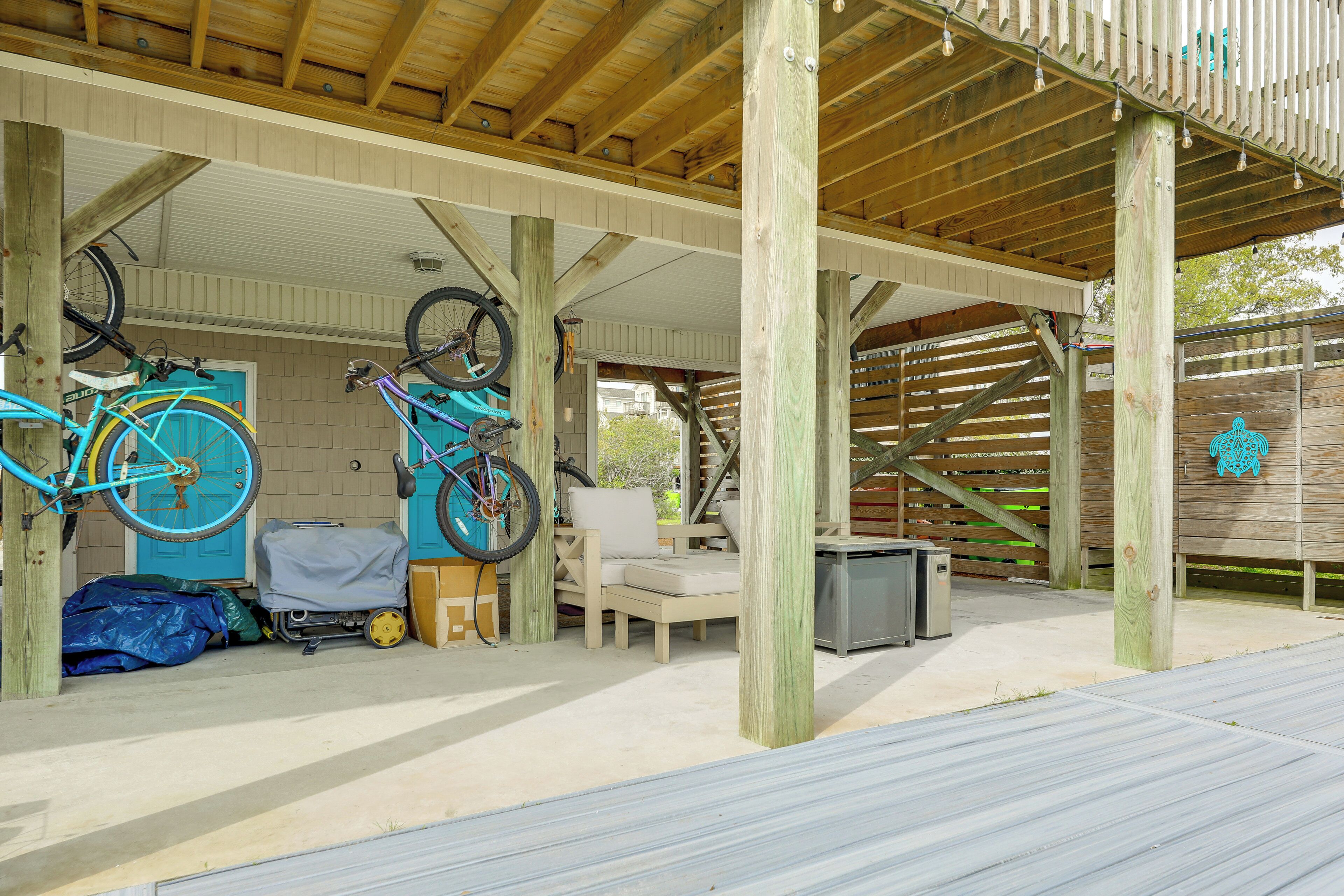 A covered outdoor area with wooden beams, a bicycle rack, a chair, and a small table.