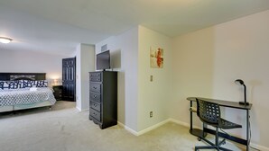 A bedroom with a bed, dresser, desk, chair, and a TV. - Detroit Vacation Rental w/ Porch & Fenced Backyard (Highland Park)