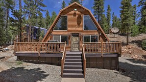 A log cabin with a front deck, large windows, and a staircase leading to the entrance. - Cozy Duck Creek Cabin ~ 12 Mi to Nat'l Forest (Duck Creek Village)