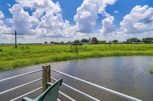 Un río con una cruz de madera y un banco verde al frente.