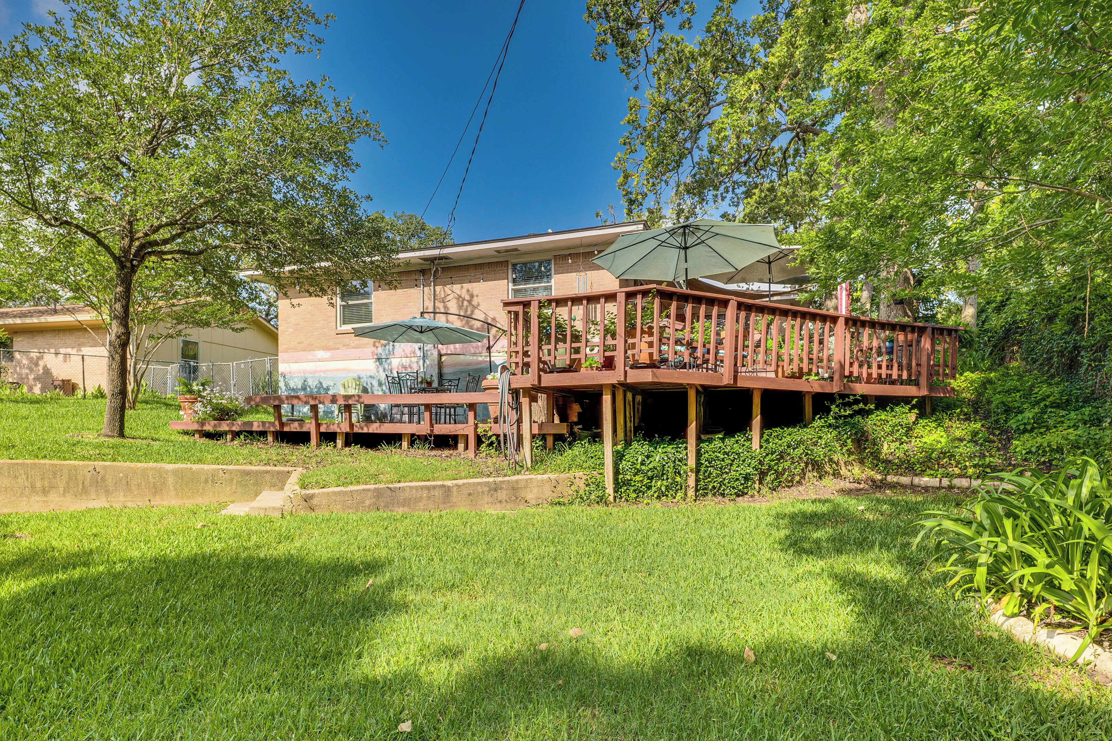A house with a wooden deck, outdoor seating, and a covered patio area.
