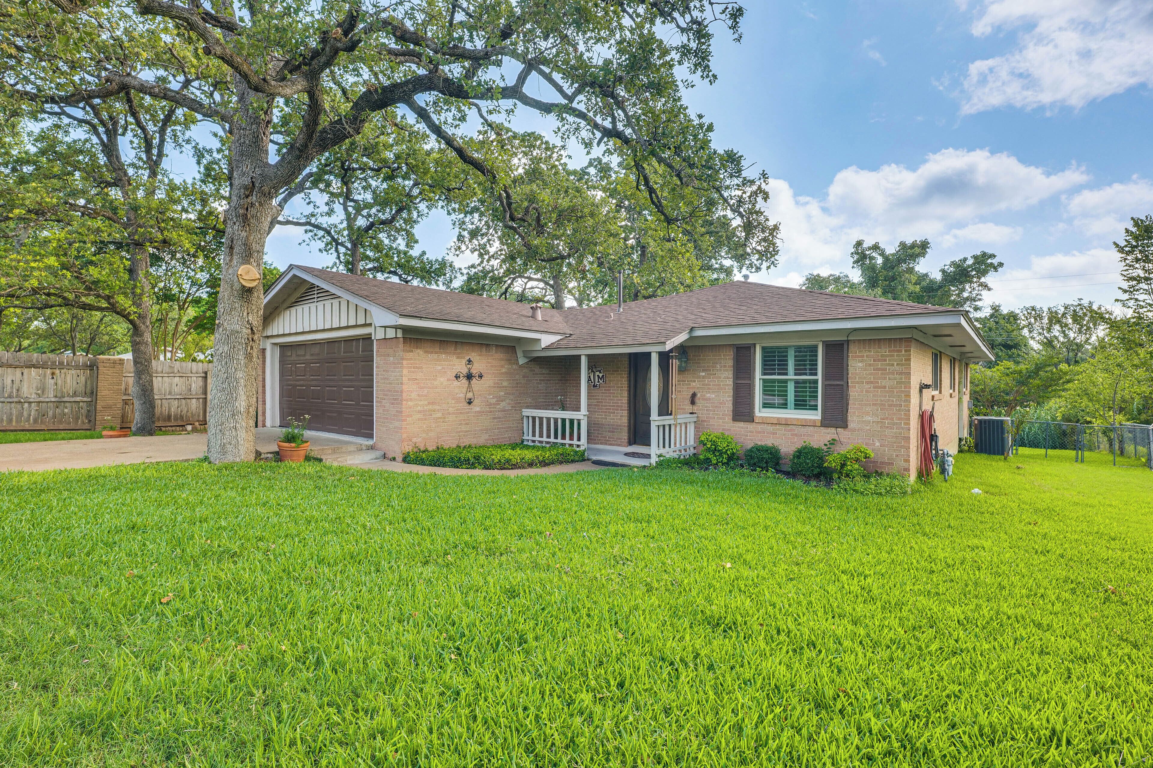 A single-story house with a front garage, a covered porch, and a well-maintained lawn.
