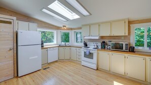 A modern kitchen with a refrigerator, stove, microwave, and wooden cabinets.