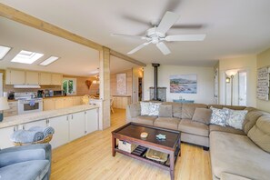 A spacious living room with a large sofa, a coffee table, and a ceiling fan. - Cozy Langley Retreat: Water Views & Beach Access (Langley)