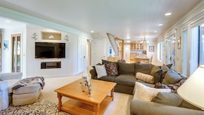 A spacious living room with a large TV, a wooden coffee table, and a cozy seating area with a sofa and armchairs. - Spacious Tahoe City Retreat < 2 Mi to Lake Tahoe! (Tahoe City)