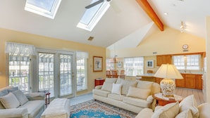 A spacious living room with a large window, a ceiling fan, and a cozy seating area. - Ocean City Home 1 Block to Beach & Boardwalk! (Ocean City)